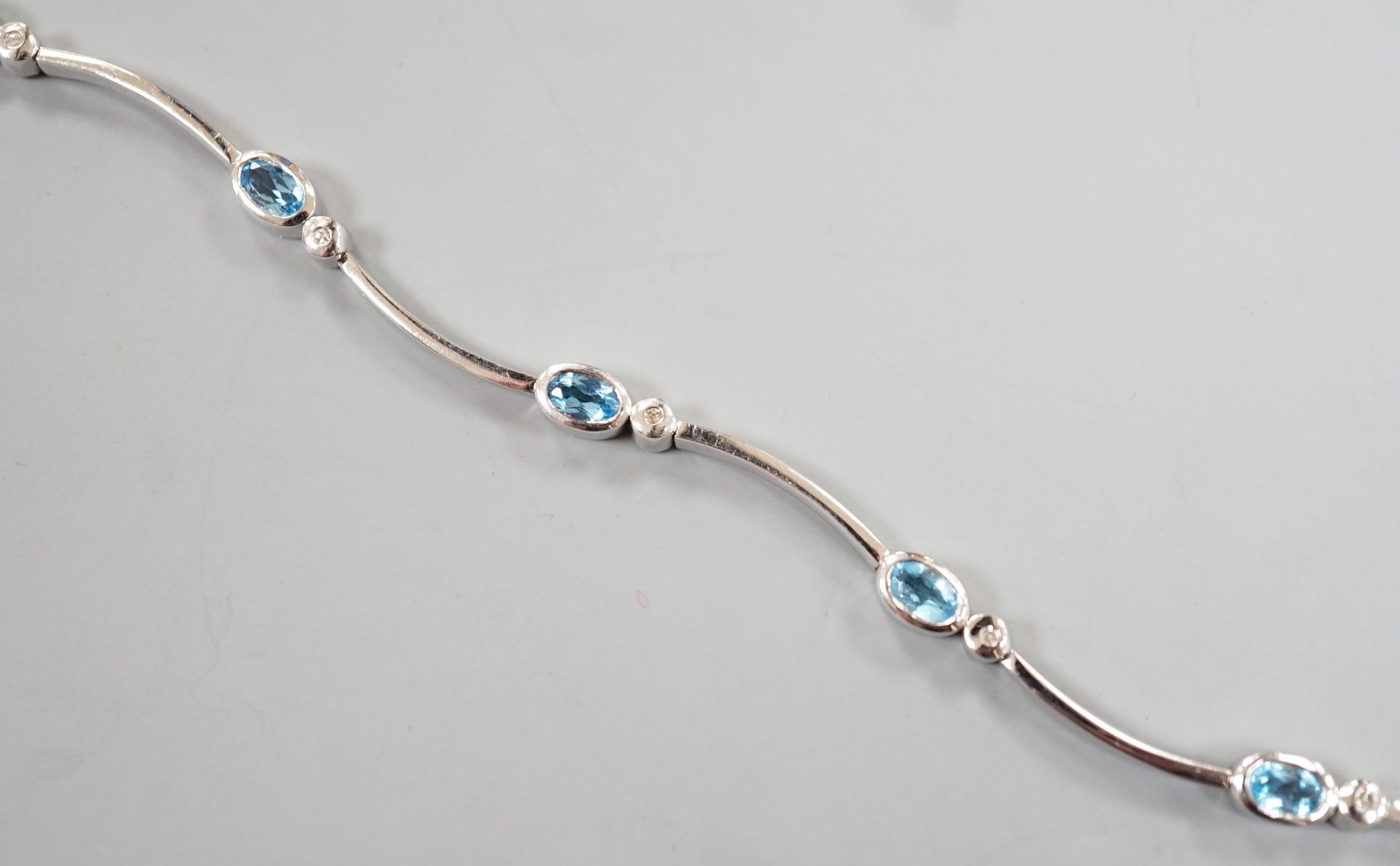 A modern 9ct white gold, blue topaz? and diamond chip set bracelet, 18.5cm, gross 8.8 grams.